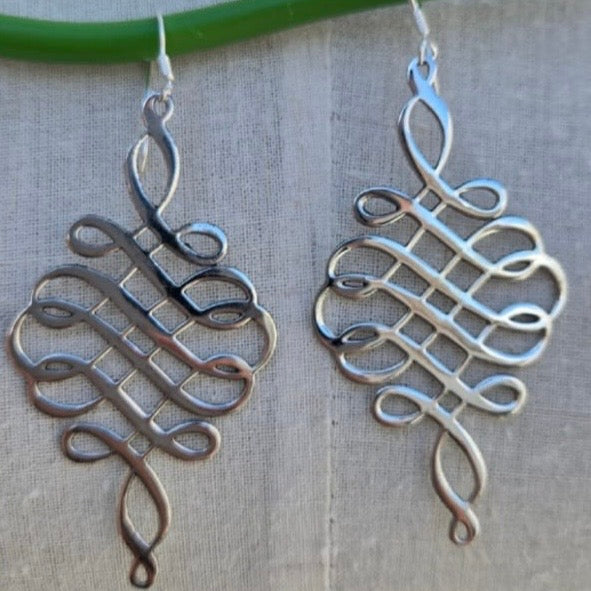 Silver Celtic knot earrings on a neutral background
