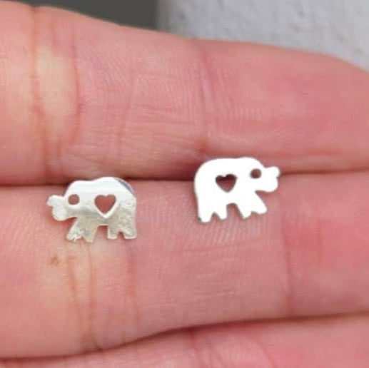 Silver elephant earrings with heart details on a hand