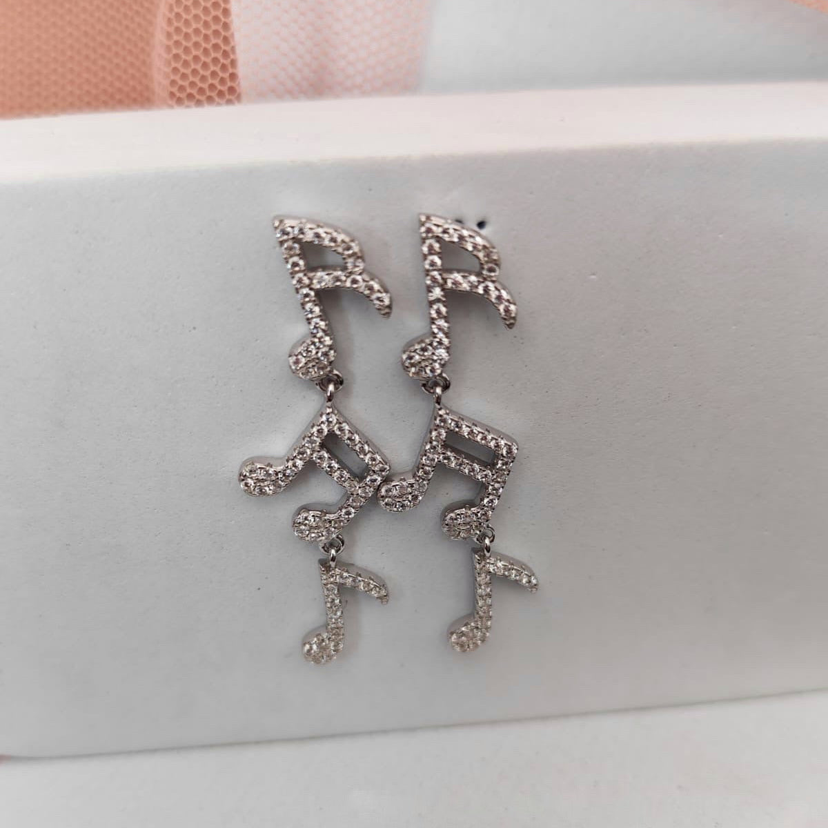 Silver earrings on a light gray surface