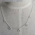 Silver necklace with heart-shaped pendants on a mannequin.