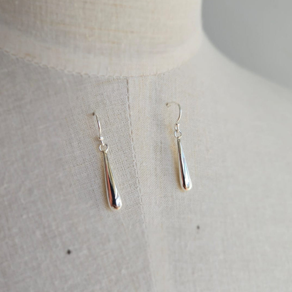 Silver earrings on a light gray background
