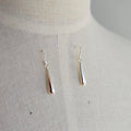 Silver earrings on a light gray background