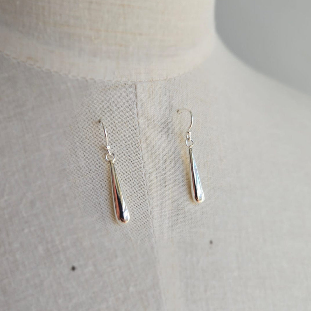 Silver earrings on a light gray background