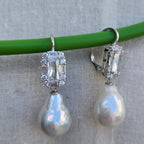 Pearl earrings with silver accents on a gray background