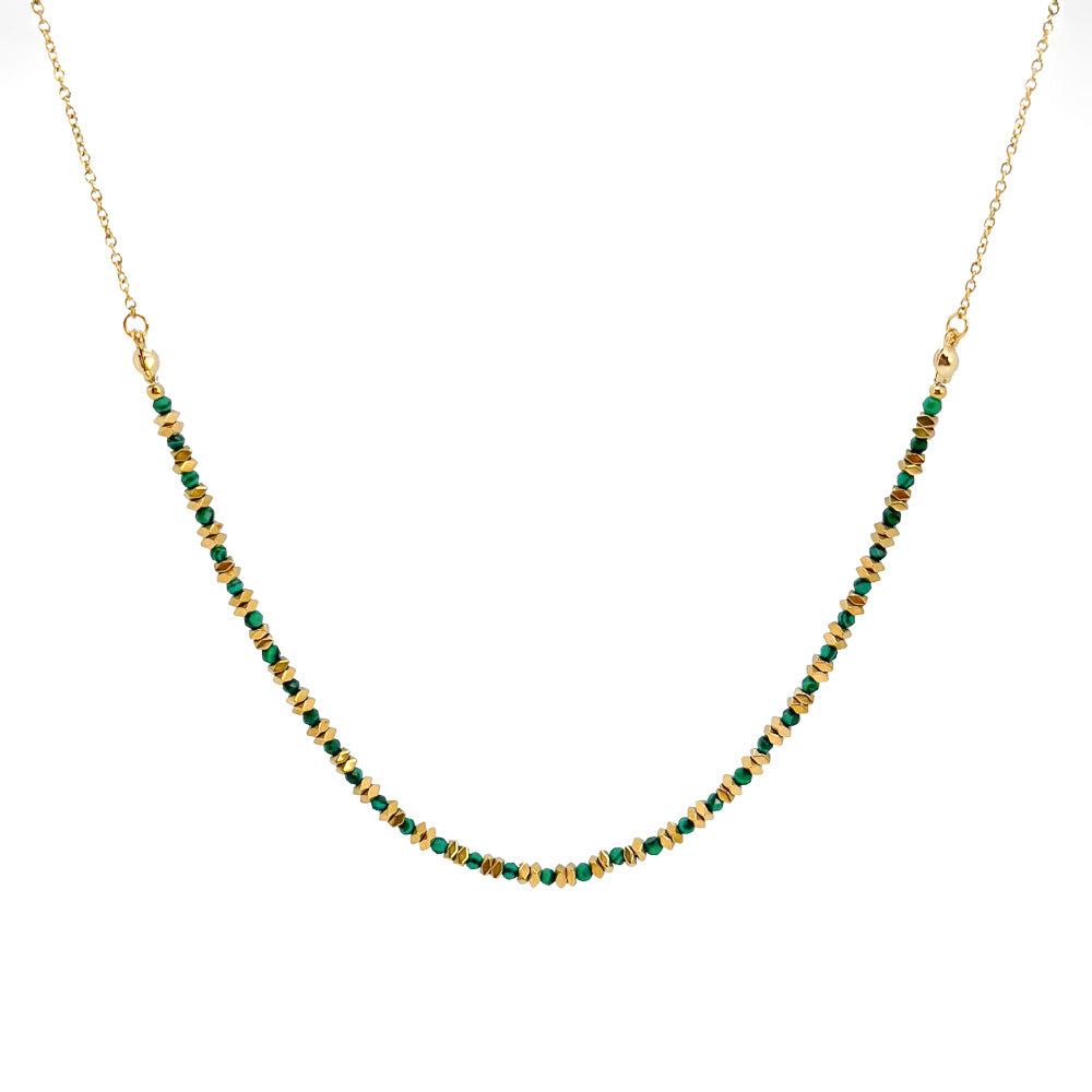 Necklace with green beads on a gold chain against a white background