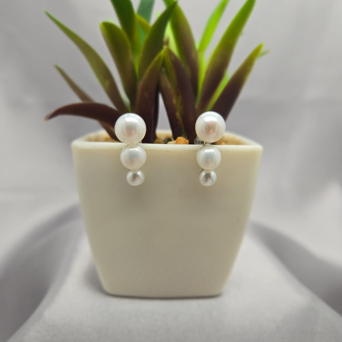 Three pearl stud earrings