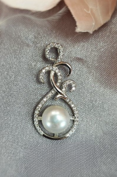 Intrigue looking sterling silver pendant with cubic zirconia insets rounding a beautiful freshwater pearl