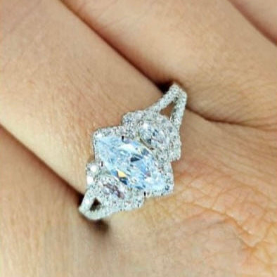 A sterling silver ring with three oval-cut cubic zirconia stones, displayed on a human hand.