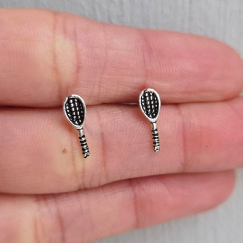 Silver tennis racket earrings on a hand