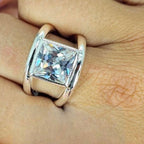 A sterling silver ring with a rectangular cubic zirconia on a person's hand.