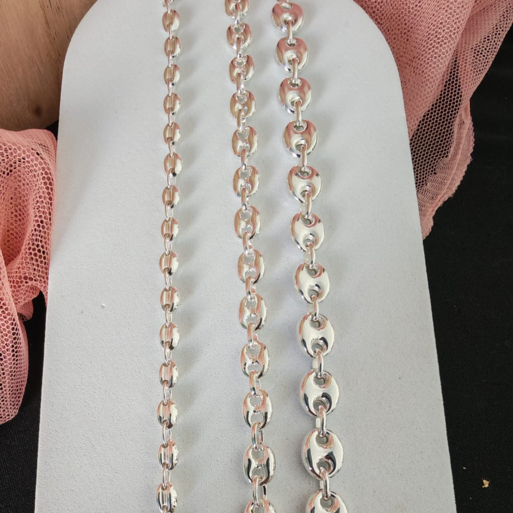 Silver chain necklace on a white card with pink fabric background