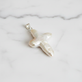 A silver-colored freshwater pearl pendant with a cross-shaped design, attached to a sterling silver hook.