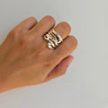 A sterling silver ring with a modern pattern detail on a person's hand.
