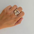 A sterling silver ring with a modern pattern detail on a person's hand.