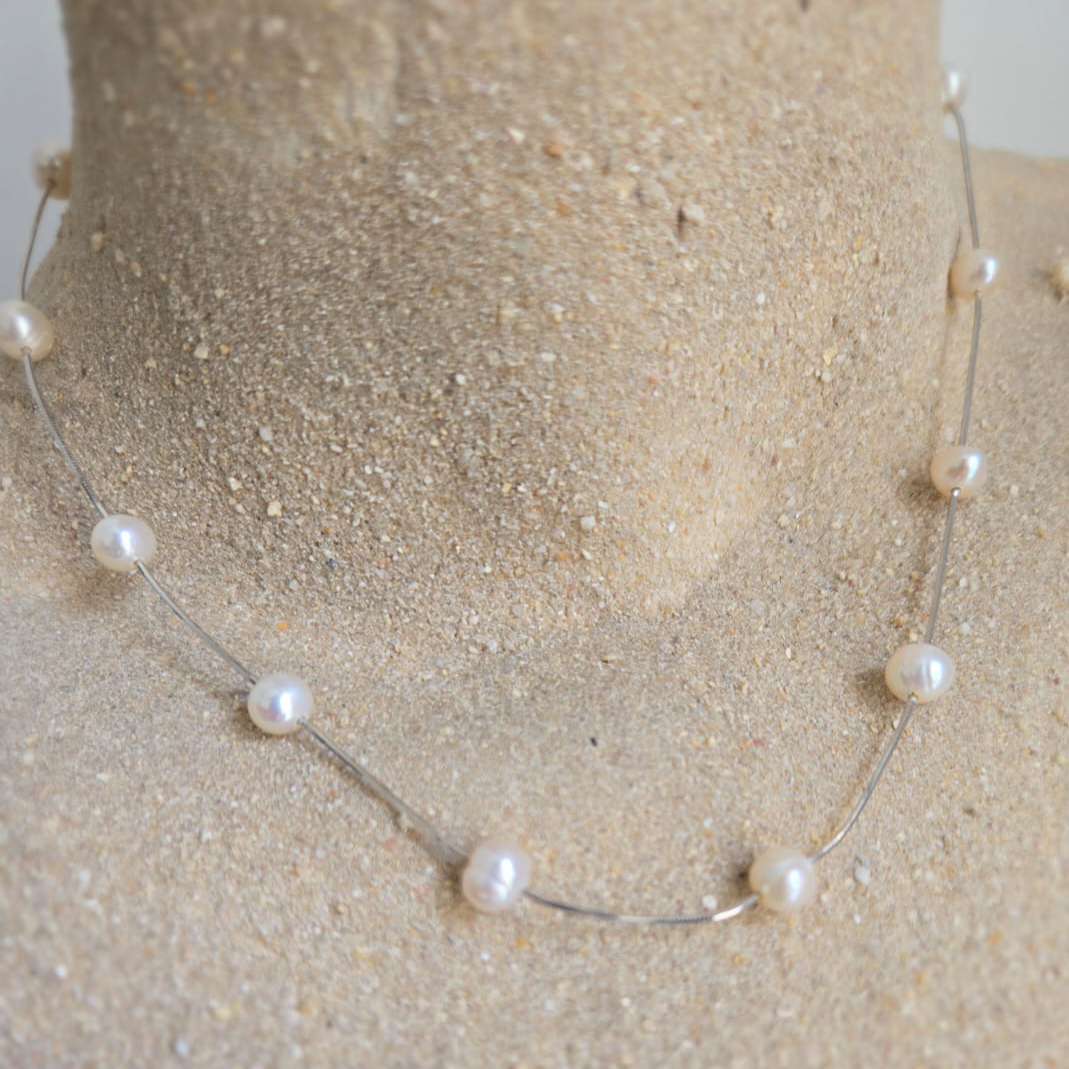 Pearl necklace on a mannequin bust with a neutral background