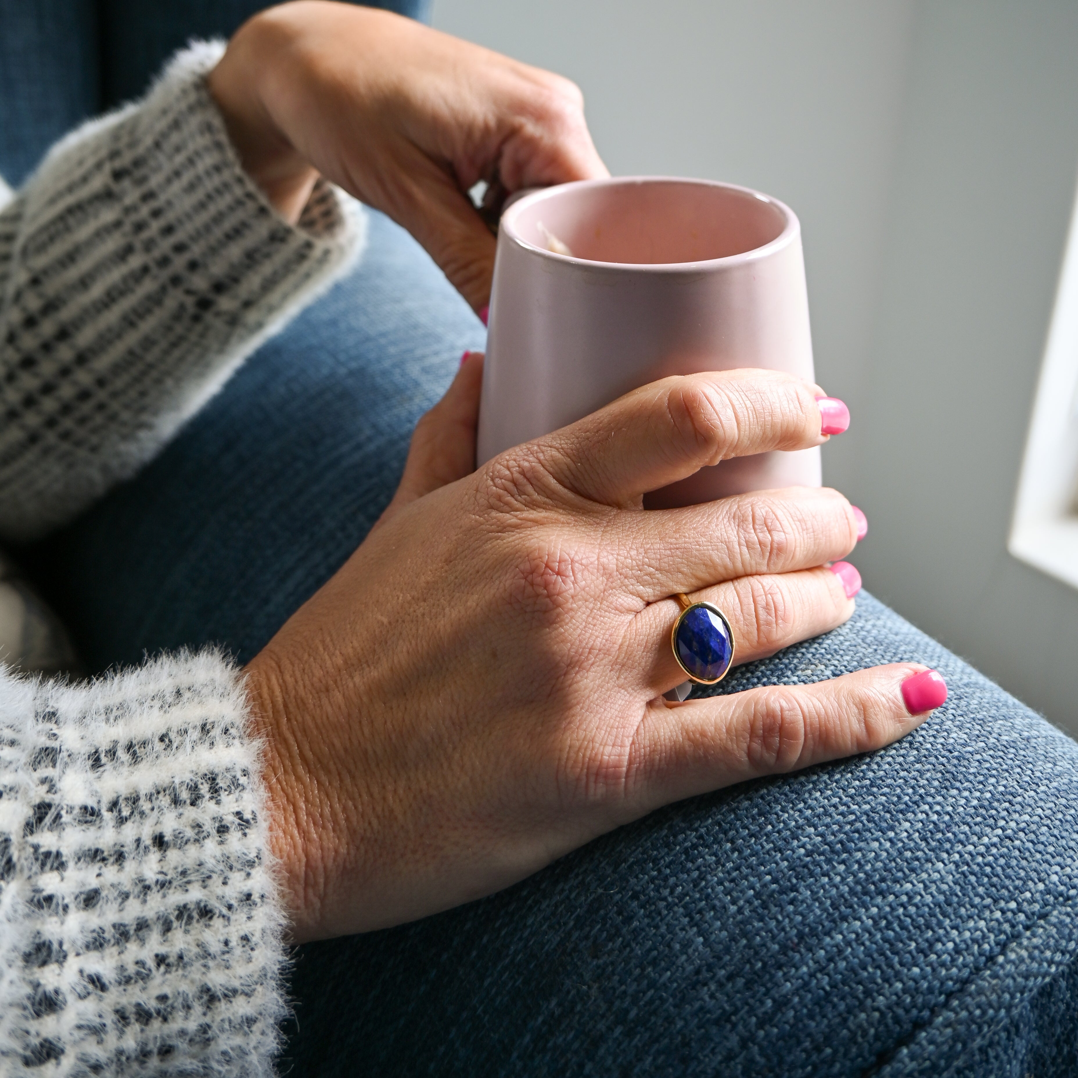 Person holding a pink mug with a blurred background