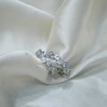 Silver ring with embedded stones on a white fabric background