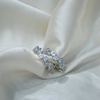 Silver ring with embedded stones on a white fabric background