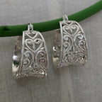 Silver filigree earrings on a gray background