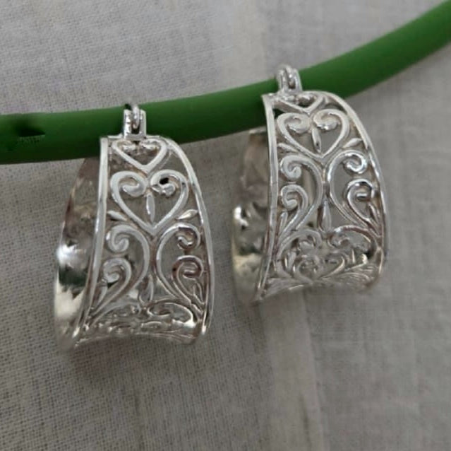 Silver filigree earrings on a gray background
