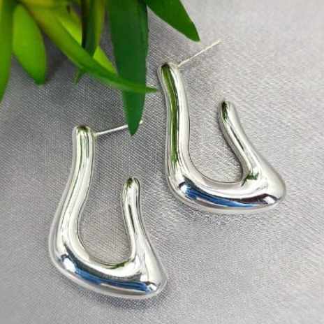 A pair of 39mm modern shape tube hoop earrings made from sterling silver, displayed against a plant backdrop.