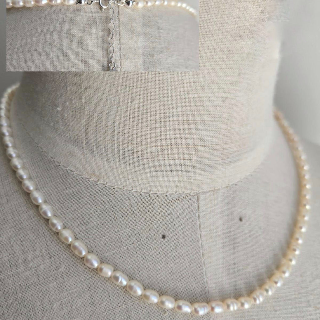 Pearl necklace on a mannequin with close-up inset showing clasp details.