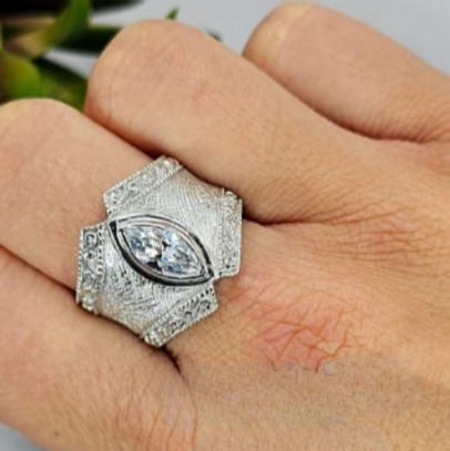 A sterling silver ring with a central cubic zirconia stone, surrounded by smaller zirconia stones set in a geometric pattern.