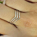 A sterling silver triple wishbone ring worn on a person's finger, showing the ring's elegant design with three separate bands.