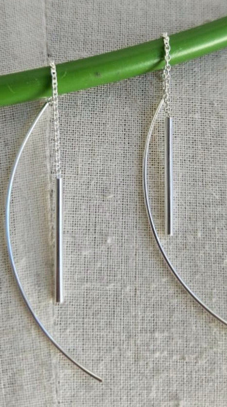 Silver earrings on a gray background