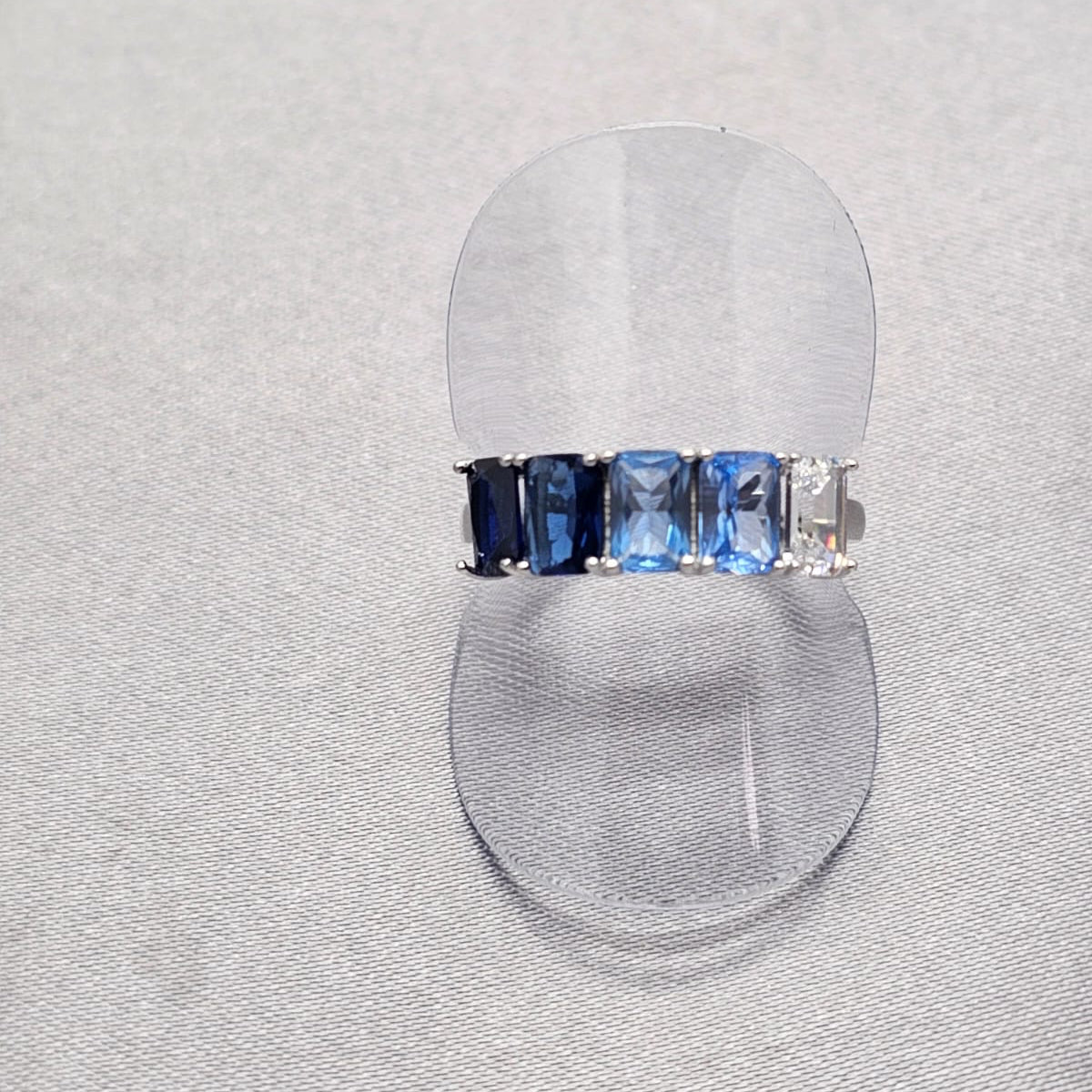 A sterling silver ring with a blue baguette cut of cubic zirconia, displayed on a plain background.
