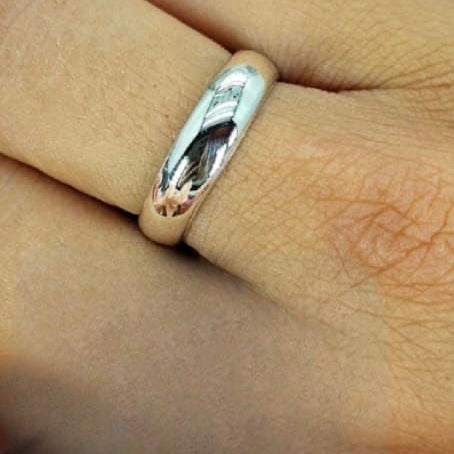 A sterling silver ring band on a human hand, showcasing its fit and shine.