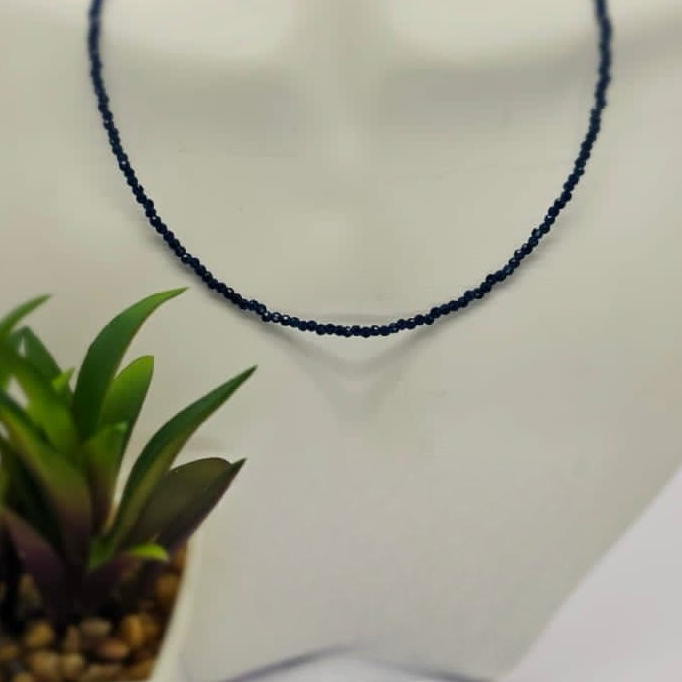 A blue sapphire semi precious stone necklace with a sleek sterling silver clasp, displayed on a mannequin.