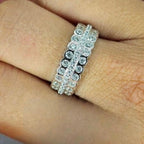 A woman's hand displaying a sterling silver three-row cubic zirconia band ring on her finger.