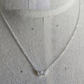 Silver necklace with heart pendant on a mannequin.
