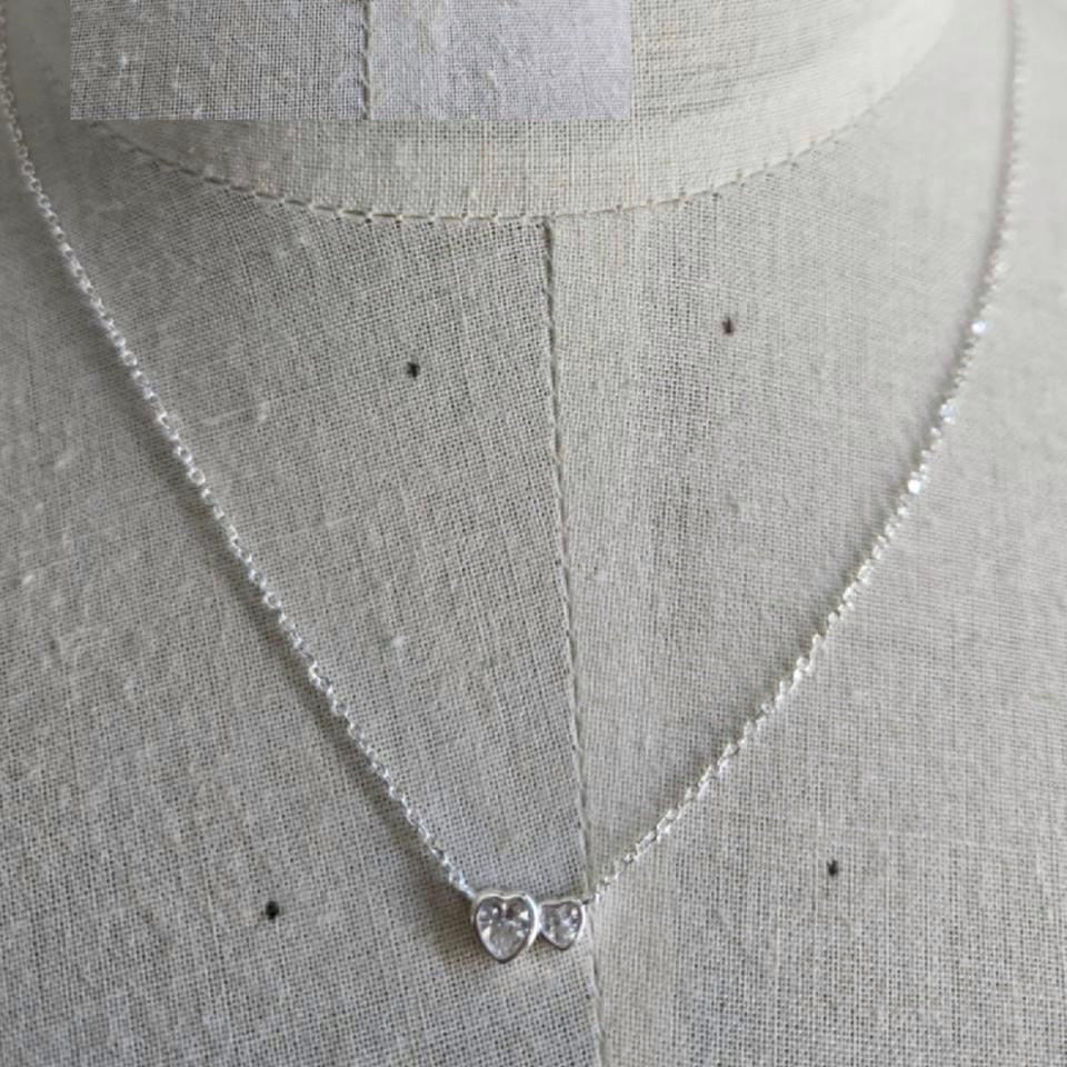 Silver necklace with heart pendant on a mannequin.