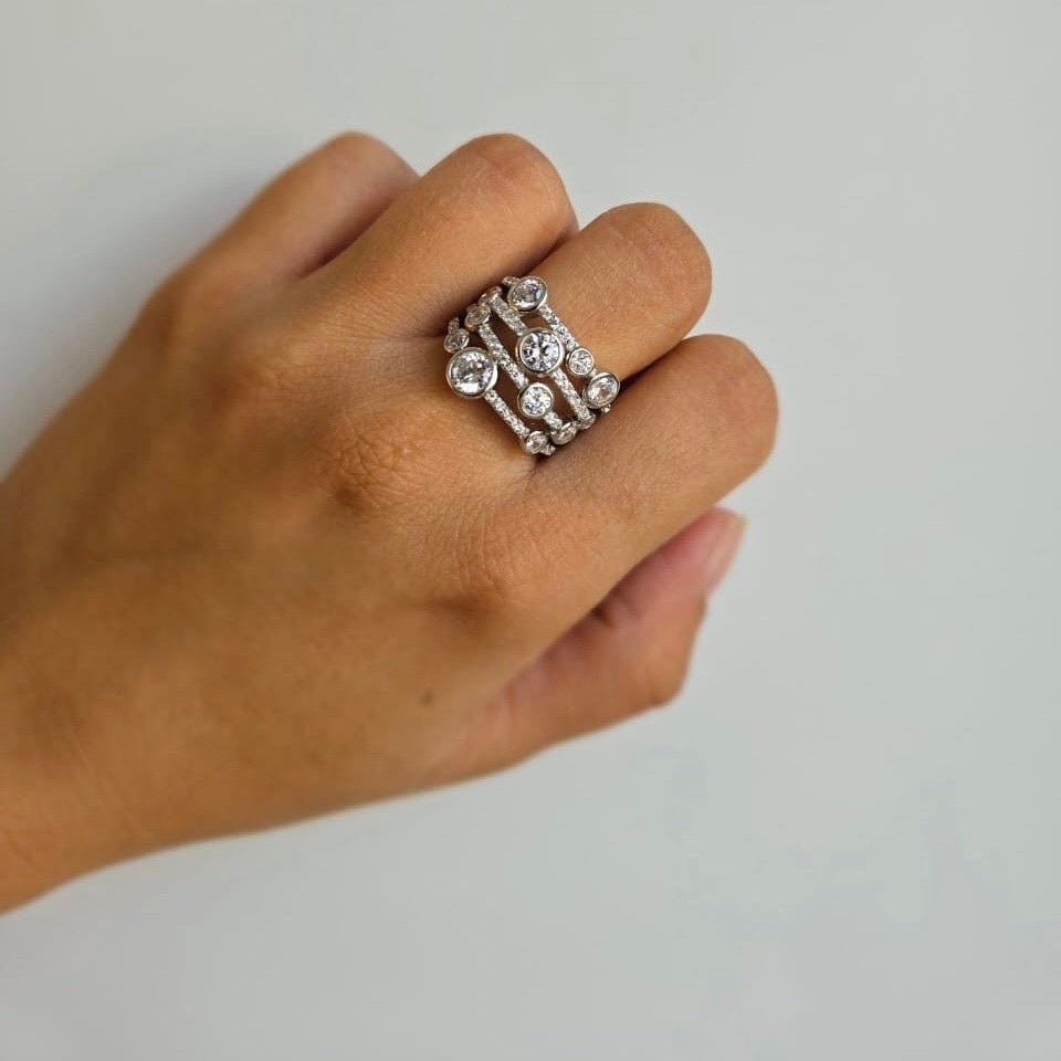 A sterling silver ring with cubic zirconia details worn on a person's finger, displayed against a neutral background.