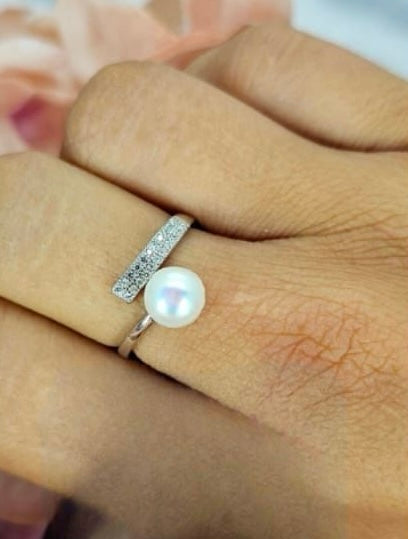 Adjustable sterling silver ring with cubic zirconia bar on one side and freshwater pearl on other one