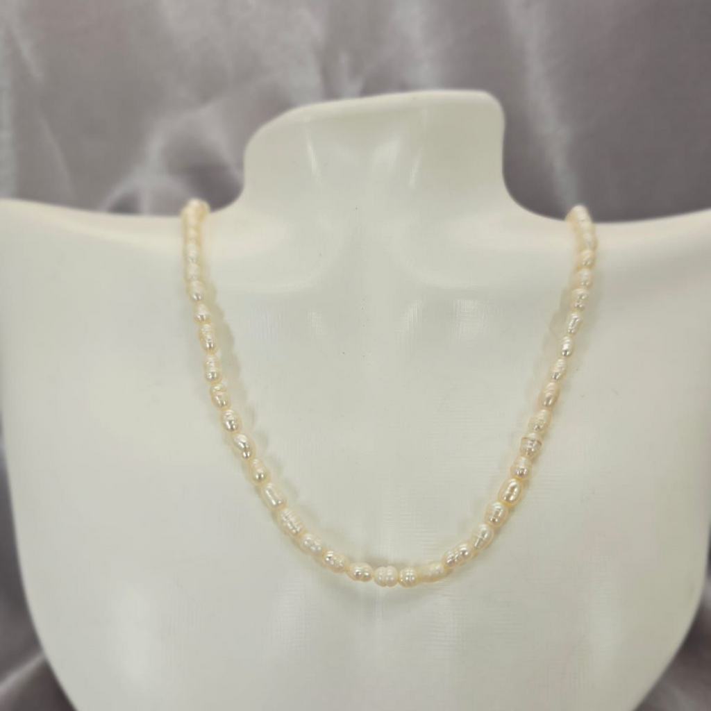 A freshwater pearl necklace with a sterling silver clasp displayed on a mannequin bust.