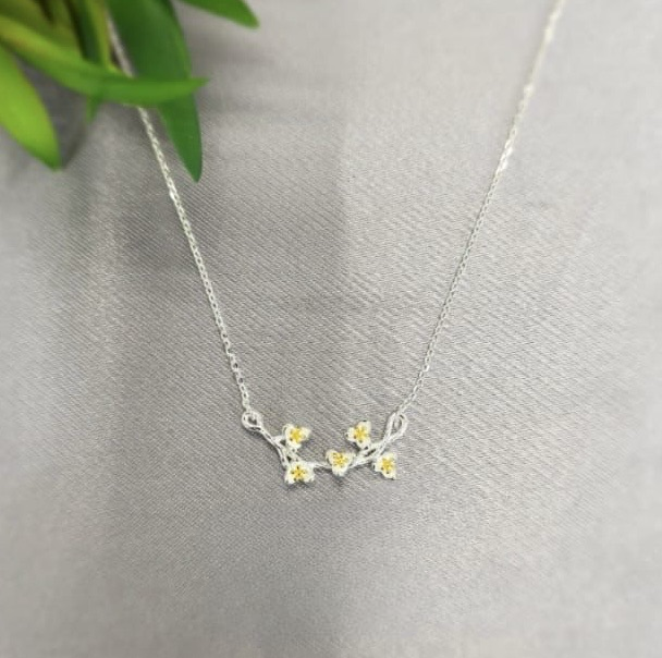 A sterling silver necklace featuring a detailed flower pattern, displayed against a neutral background.