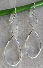Silver teardrop earrings on a gray background