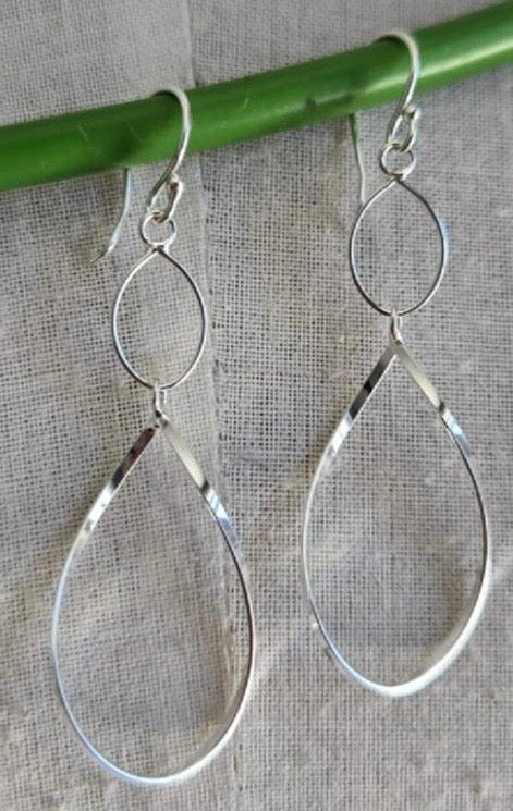 Silver teardrop earrings on a gray background