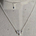 Silver bee necklace on a light gray background