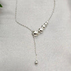 A sterling silver necklace with a series of ball details on a chain, displayed against a light background.