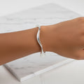 A sterling silver hollow wave bracelet displayed on a person's wrist, with the bracelet's width indicated as 6mm.
