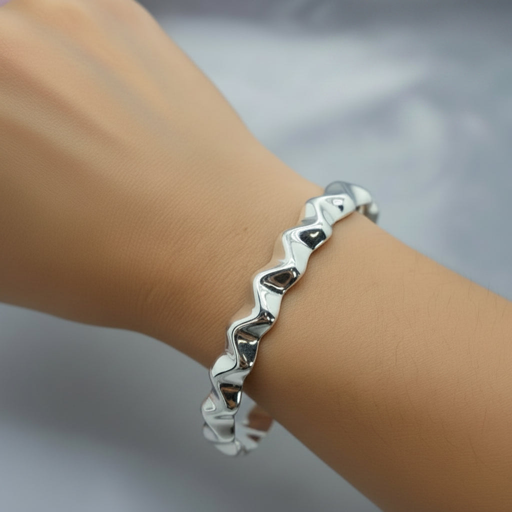 A sterling silver hollow Zig Zag bracelet on a person's wrist, with a label showing the width at 10mm.