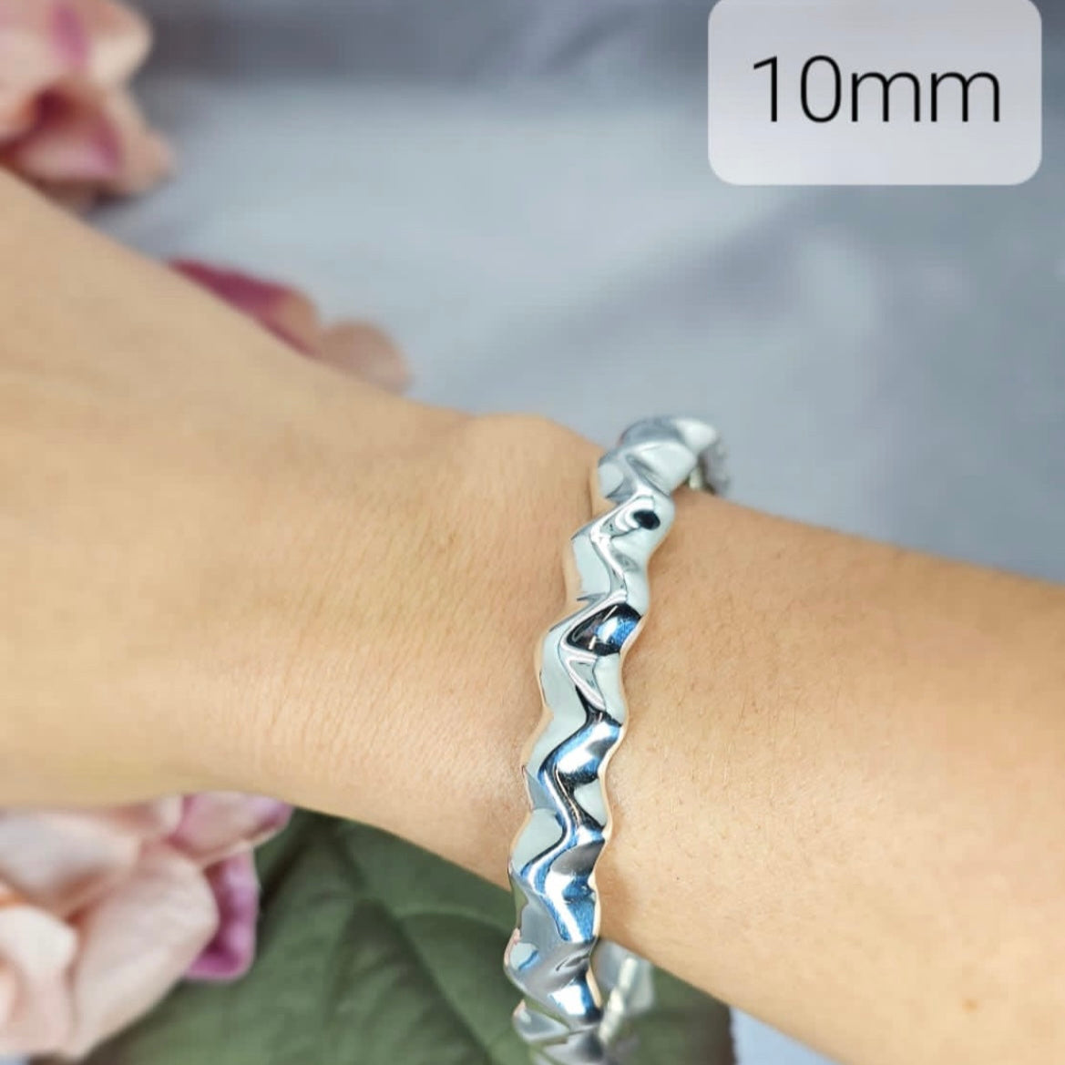 A sterling silver hollow Zig Zag bracelet on a person's wrist, with a label showing the width at 10mm.