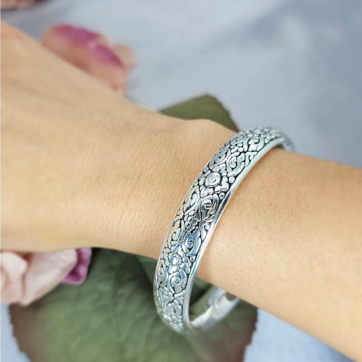 A sterling silver bracelet with a bold pattern worn on a person's wrist, with a label showing the width of 13mm.