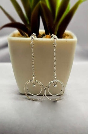 Chain drop earrings with double circle ends and dangling ball