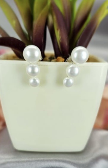 Three pearl stud earrings