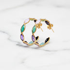 Gold hoop earrings with multicolored gemstones on a white background